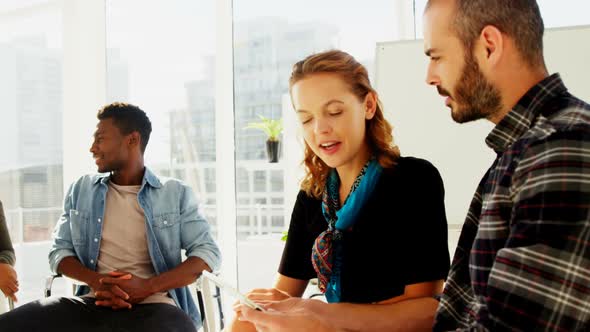 Business colleagues discussing over digital tablet