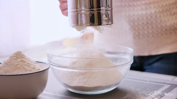 Closeup of Bakery Concept  Woman Sift Flour Through Metallic Sieve to Glass Bowl for Baking