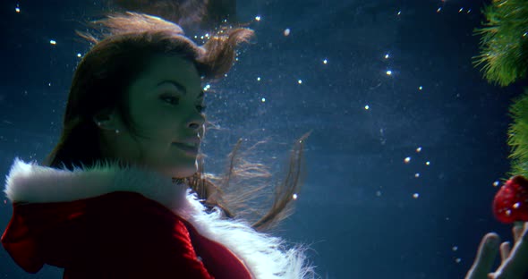 Charming Young Brunette Woman Is Floating Underwater, Christmas Concept