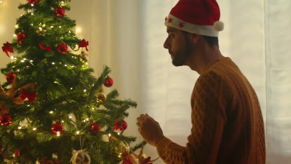 guy prepare Christmas tree decoration