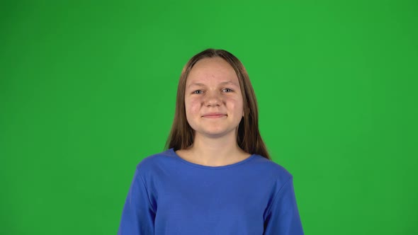 Girl Smiling Looking at Camera on Green Background.