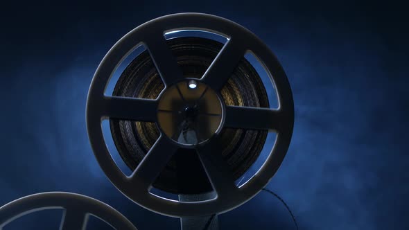 Film Is Wound Onto a Reel Projector. Dark Background with Backlight alt