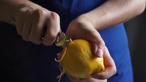 Woman removes lemon zest with a kitchen object