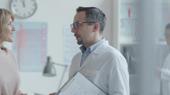 Cheerful Male Doctor and Female Patient Posing for Camera