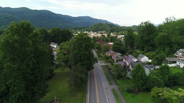A slowly rising aerial establishing shot of a residential neighborhood in the Virginia hills. A smal