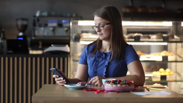 woman makes a video call via a phone in a cafe