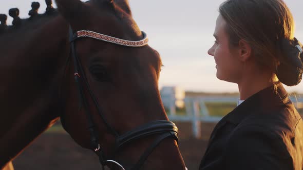 Blond Woman With Her Dark Brown Horse Caressing And Stroking Her Horse With Love