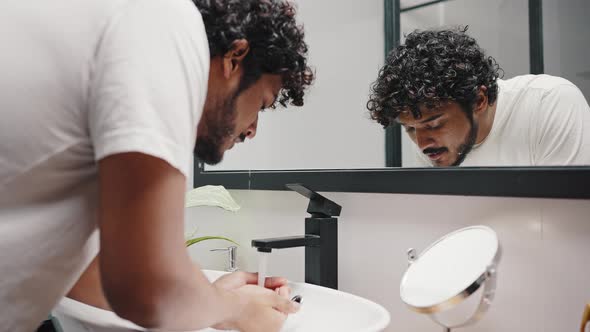 Young Bearded Hindu Man Washes Face Wiping with Towel