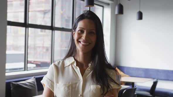 Portrait of happy mixed race businesswoman smiling to camera in office