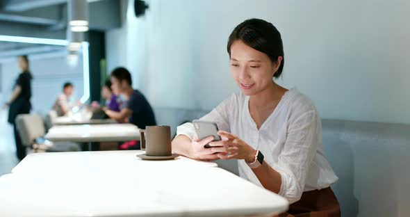 Woman check on cellphone in cafe