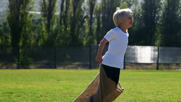 Children playing a sack race in park