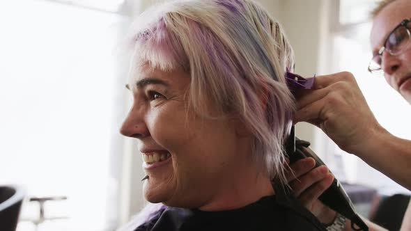 Side view woman shaving her hair at the hairdresser