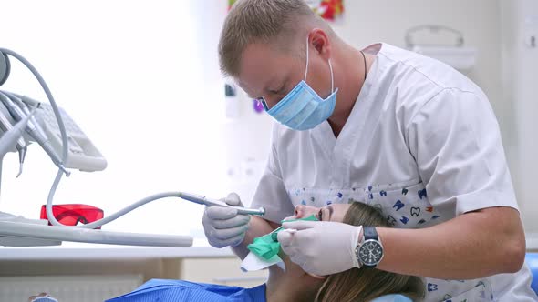 Dentist working in stomatology clinic. Woman in stomatology clinic with male dentist