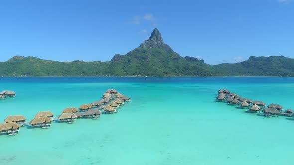 Aerial drone view of a luxury resort and overwater bungalows in Bora Bora tropical island.