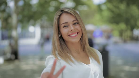 Girl Waving Hand and Smiling at Camera