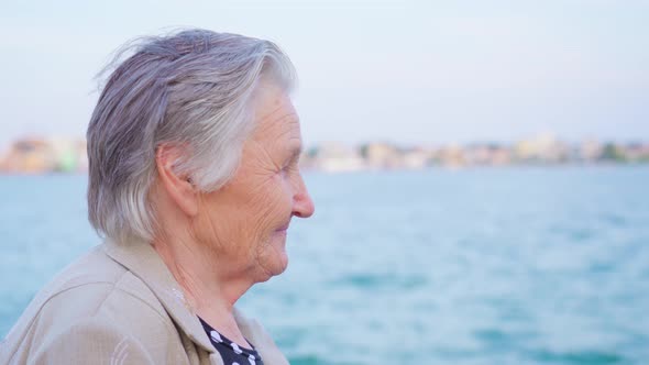 Grey Haired Lady Traveler Enjoys View Standing on Promenade