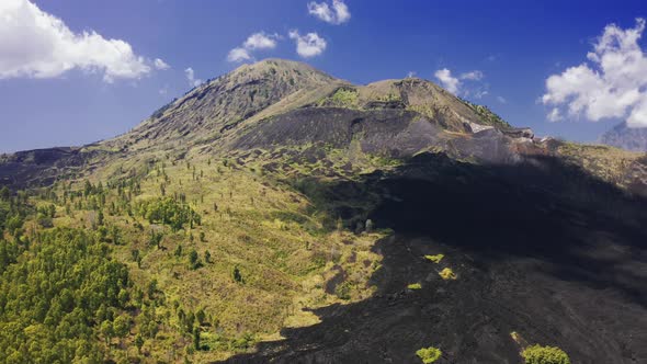 Frozen Black Lava and Green Trees on the Slope of Volcano Batur on Bali, Indonesia. Aerial View 