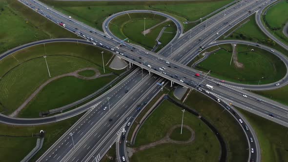 Cars Drive Along Multilevel Traffic Intersection on Meadows