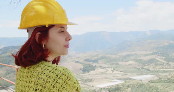 Young female engineer looks at the panorama from the mountain