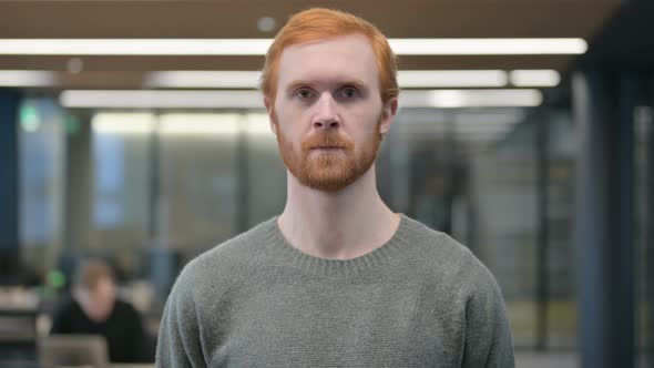 Portrait of Serious Young Man Looking at the Camera