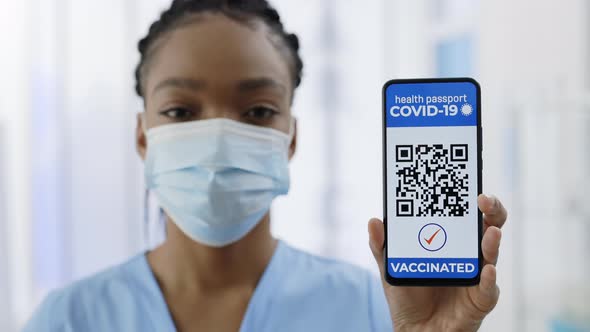 Close Up of Female Doctor Showing Smartphone in Her Hand with Mobile Application for Vaccination