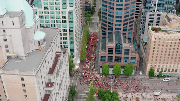 Circling drone overhead view of the Cancel Canada Day Protest March in Vancouver BC Canada. Indigeno