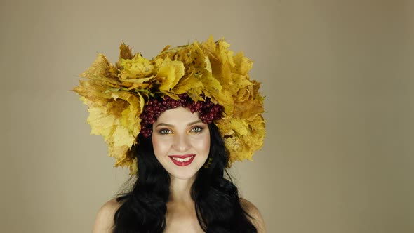 Beautiful Black Haired Girl with Bright Autumn Wreath of Leaves and Flowers Smiling in Studio