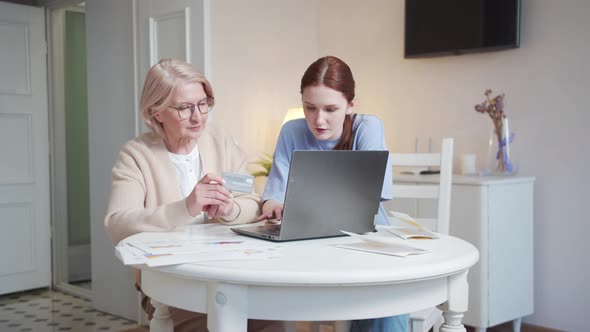 Woman Explains to a Pretty Pensioner How to Pay for Purchases on the Internet