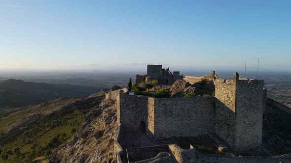 A drone flies over the walls of Marvão Castle showing people walking within.