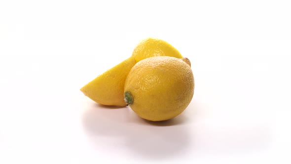 Two Fresh Cutted Yellow Lemons are Spinning on White Background