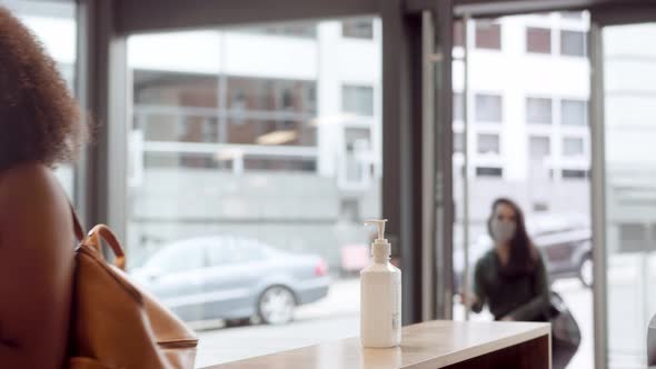 Office Workers Using Hand Sanitiser In Reception As They Arrive For Work During Health Pandemic