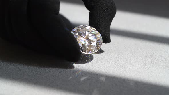 Big Diamond Sparkling in Hands Jewelry Inspection