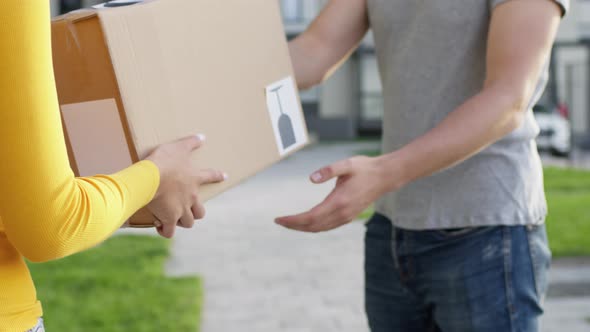 Goods Delivery. Customer Guy And Girl Delivery Service Worker. Guy Gets His Box. Face Invisible.