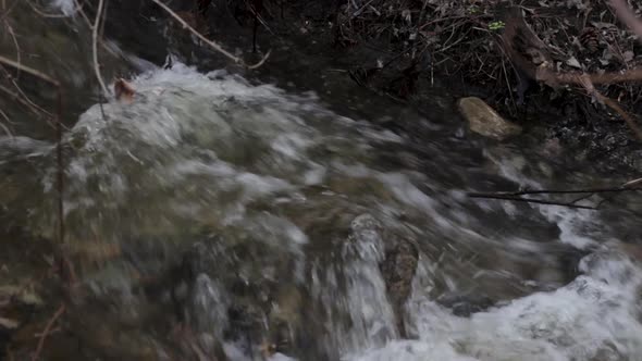 Small Creek Waterfall Splashing Down Over Rock In Spring Forest