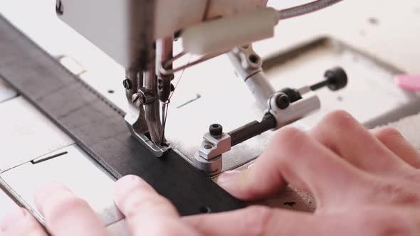 The Craftsman Stitches a Men's Leather Belt on a Sewing Machine