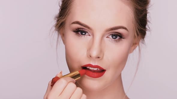 Sexy Lady Doing Make-up with Red Lipstick