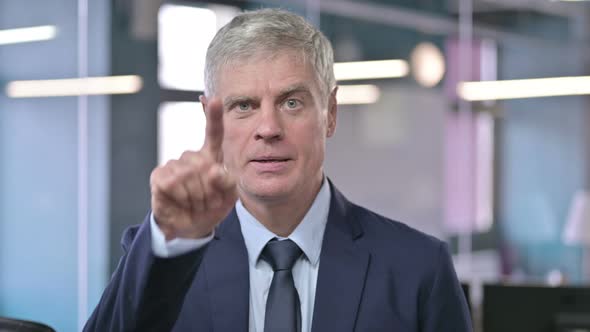 Portrait of Middle Aged Businessman Pointing Finger on Camera