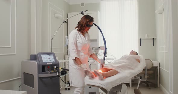 A Dermatologist Doctor Makes a Laser Treatment Procedure for a Patient's Skin