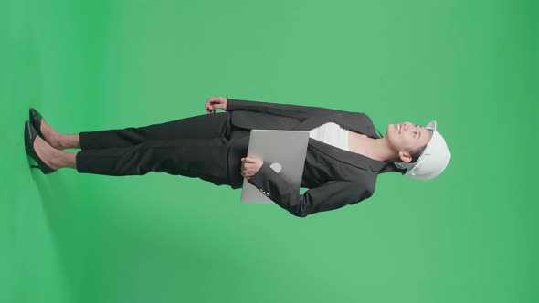 Full Body Side View Of Asian Female Engineer With Laptop Looking Around In The Green Screen Studio