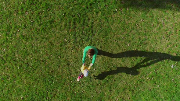 Aerial view of father rotating infant son at public playground, Zagreb, Croatia.