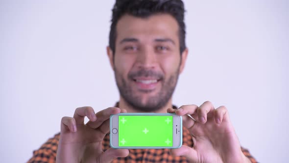 Face of Happy Bearded Persian Hipster Man Showing Phone