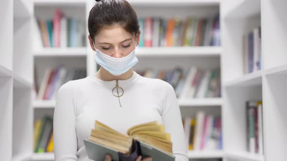 University Library: Beautiful Girl in a Mask During Quarantine Covid-19 Prepares for the Exam