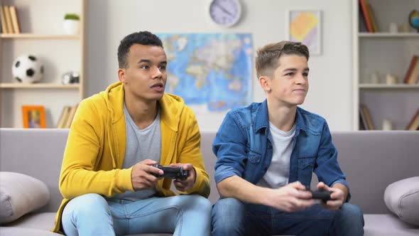 African and European Teenager Friends Losing Video Game, Accusing Each Other