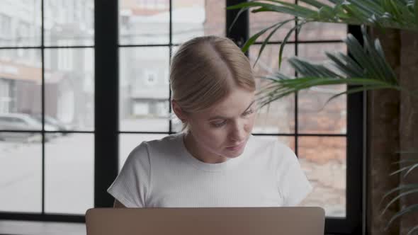 Thoughtful concerned woman working on laptop computer looking away thinking solving problem 