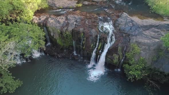 Drone footage rising and pointing towards a small waterfall