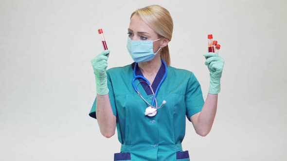 Medical Doctor Nurse Woman Wearing Protective Mask and Latex Gloves - Holding Blood Test Tube