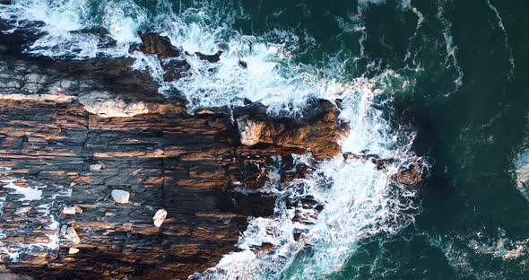 Aerial shot of the waves hitting the rock in Camden Maine USA as the sun set