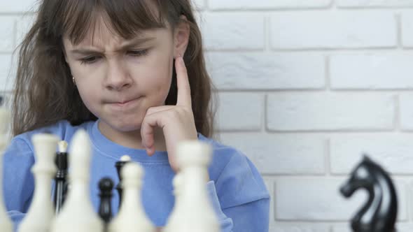 The girl is thinking over the game of chess.