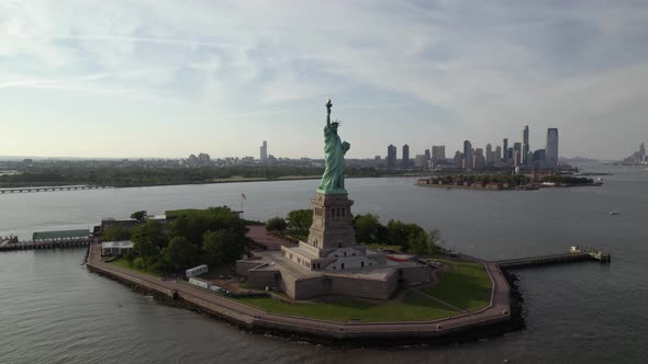 Aerial view around the Statue of Liberty, in sunny New York, USA - orbit, drone shot