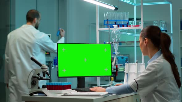 Biochemist Developing Drugs Working on Computer with Green Screen alt
